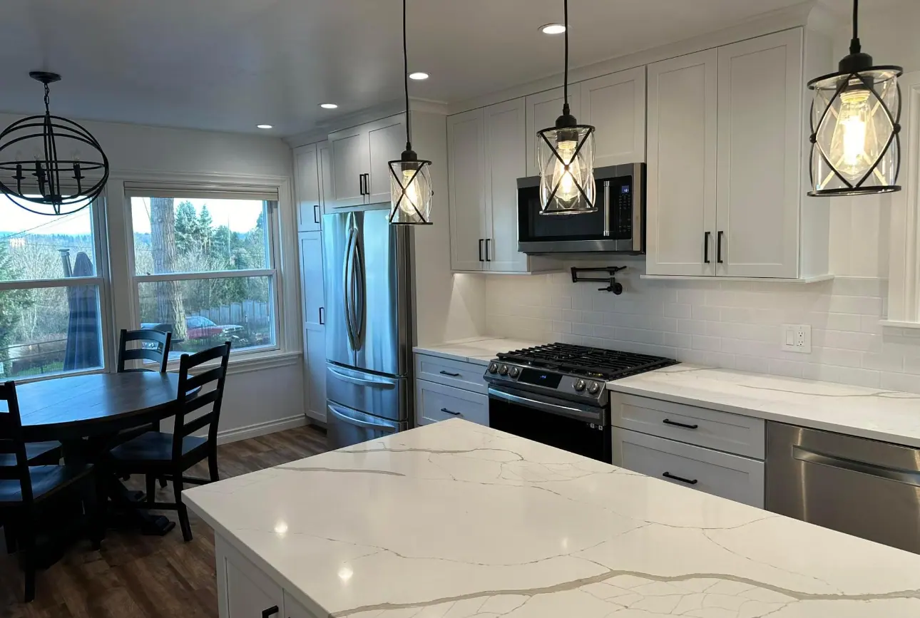 White kitchen with a quartz island and pendant lights